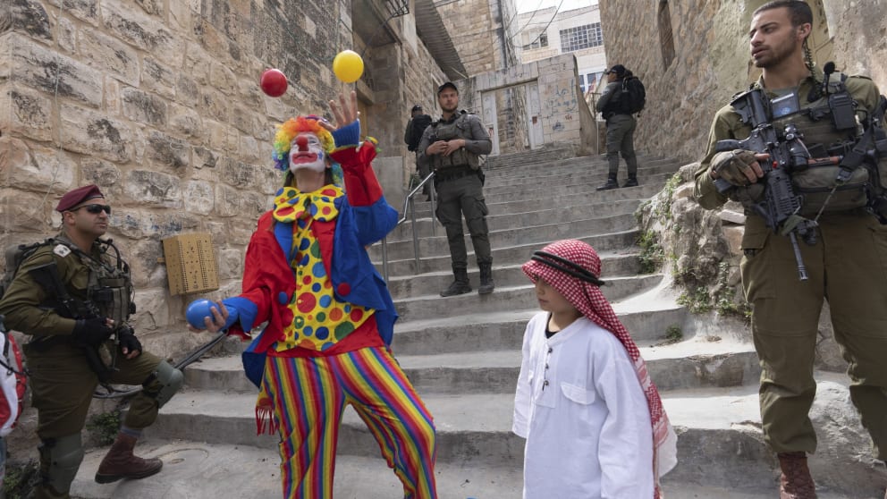 Purim in the Old City of Jerusalem, near the Wailing Wall: soldiers on duty and disguised revelers