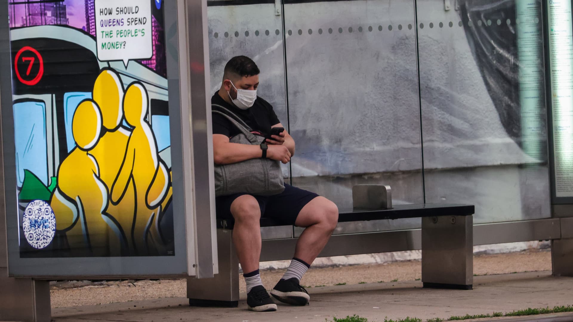 A man sits at the bus stop with a mask on his face in New York City, June 6, 2023.