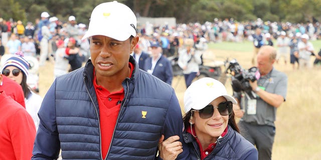 Erica Herman clings to Tiger Woods