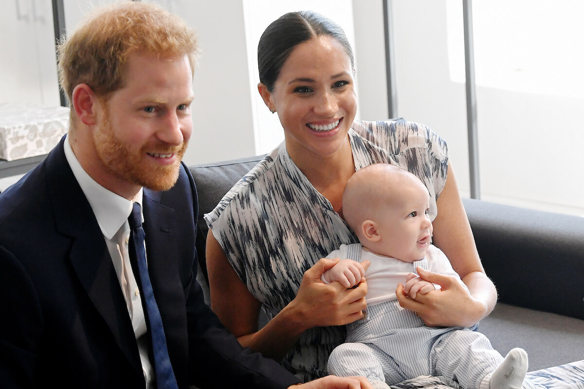 Prince Harry and Meghan Markle, whose daughter Princess Lilibet didn't get a happy birthday shoutout from the royal family in what wasn't a 'snub,' sit with Prince Archie