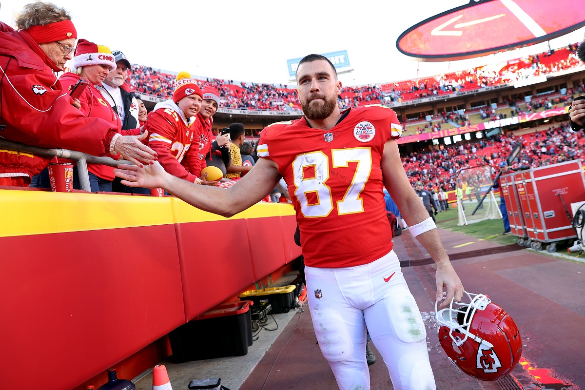 Travis Kelce #87 of the Kansas City Chiefs celebrates with fans as he walks off the field after defeating the Las Vegas Raiders 48-9 at Arrowhead Stadium on December 12, 2021