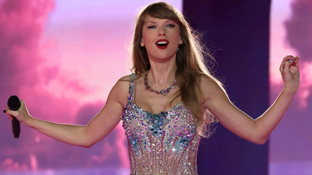 Taylor Swiftin a sparkly bodysuit looks out at the crowd