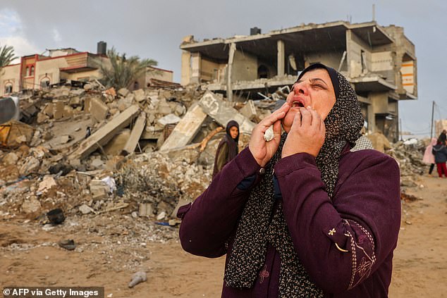 A Palestinian woman is pictured in front of the damage following Israeli strikes on Rafah, on the southern Gaza Strip, on November 20