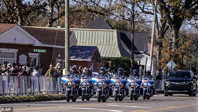 People watch the motorcade as it moves to Maranatha Baptist Church where the funeral service for former first lady Rosalynn Carter will be held