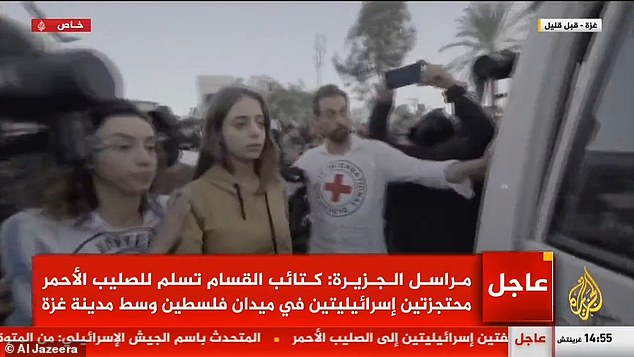 Seconds later, Mia, flanked by the gunmen and surrounded by hundreds of screaming men, looked petrified as she was put into the Red Cross vehicle
