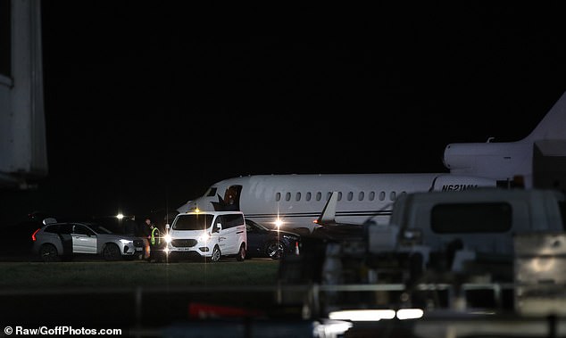 Snaps taken at London's Stansted Airport showed Taylor being taken to the plane under an umbrella and surrounded by a three-car convoy of security