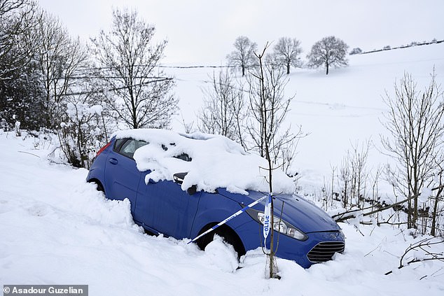 A car wrapped in police tape after it spun off the road between Kendal and Windermere during Saturday's heavy snow falls