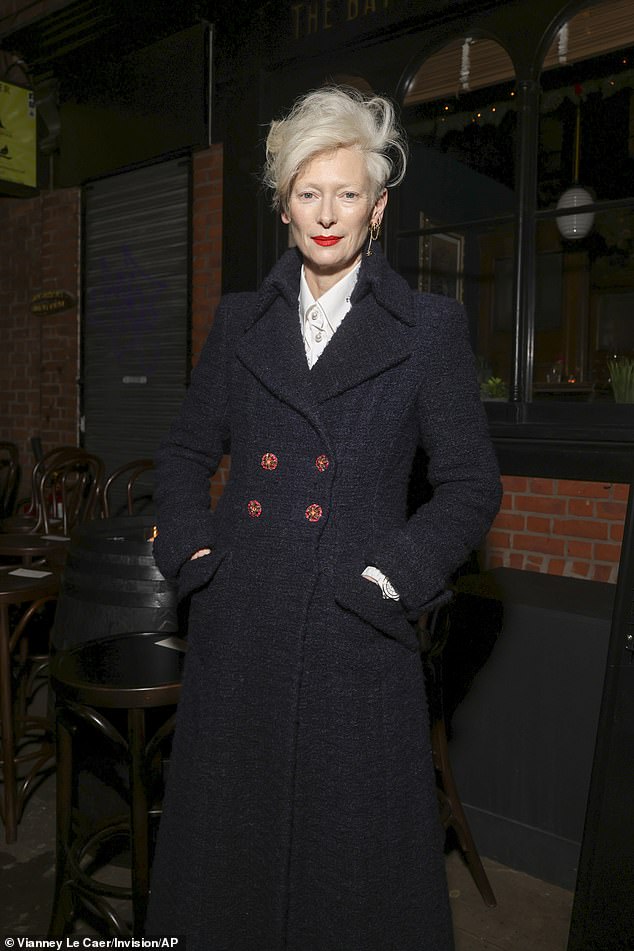 Tilda Swinton, 63, cut a sophisticated figure in a white shirt and a tweed jacket as she posed up a storm at the event