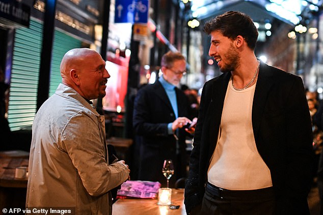 Manchester City's Ruben Dias cut a trendy figure in a white T-shirt and jeans, which he styled with a blazer